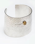 Reptilia Maxima silver cuff with yellow aragonite cabochon, angled front view.