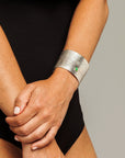 Reptilia Maxima silver cuff with green cabochon, worn on wrist.