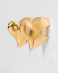 Gold heart-shaped earrings with a diamond on a light gray background